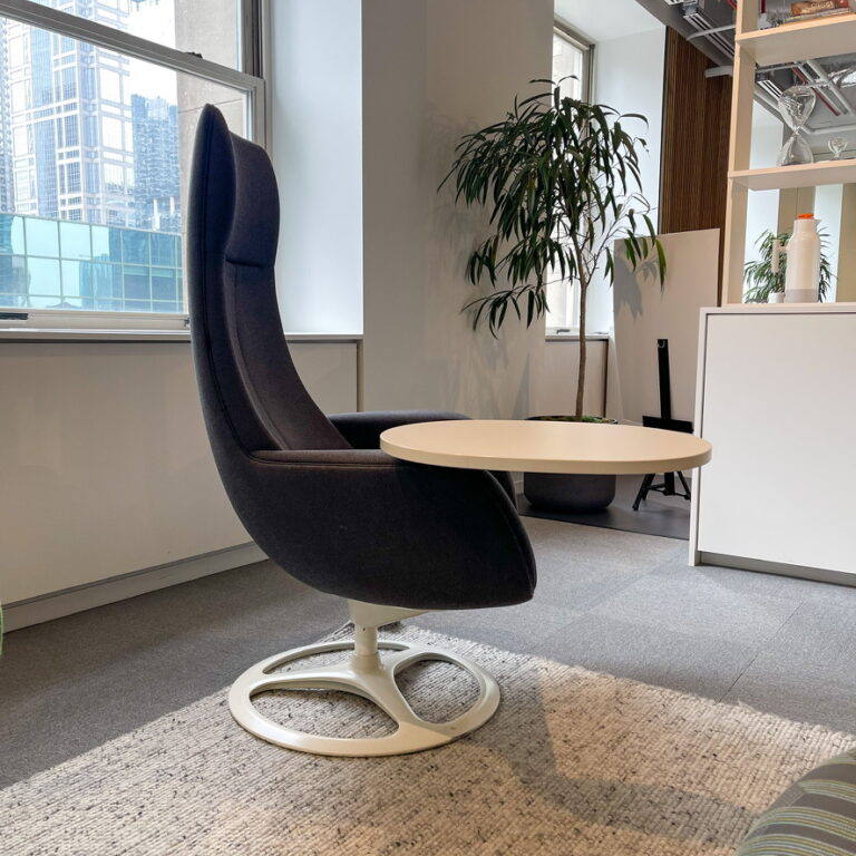 A black designer chair with a desk attached from the Okamura display at NeoCon 2023